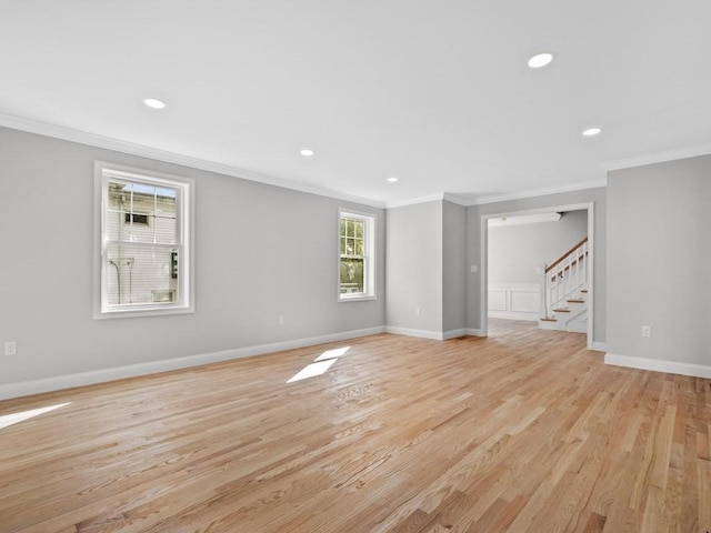 spare room featuring recessed lighting, baseboards, light wood-style floors, ornamental molding, and stairway