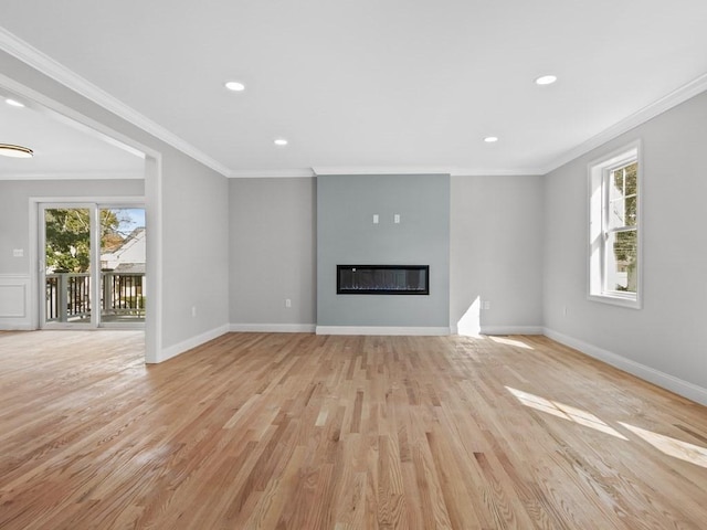 unfurnished living room featuring a glass covered fireplace, baseboards, crown molding, and light wood finished floors