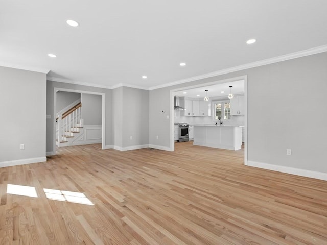 unfurnished living room with light wood finished floors, stairs, and ornamental molding