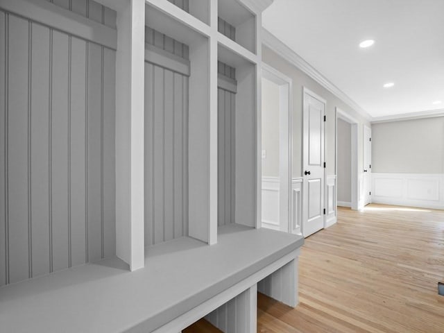 mudroom with ornamental molding, a decorative wall, recessed lighting, and light wood-style floors