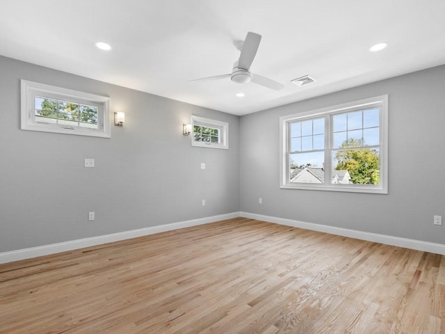 empty room featuring light wood-type flooring, visible vents, baseboards, and recessed lighting