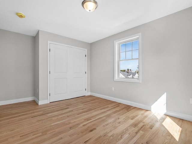 unfurnished bedroom with light wood-type flooring and baseboards