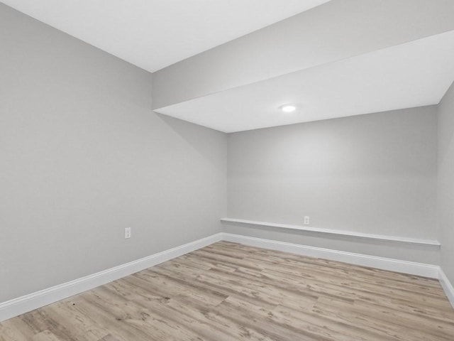 spare room featuring baseboards and wood finished floors