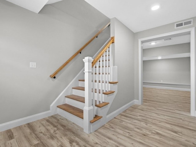 staircase with baseboards, visible vents, wood finished floors, and recessed lighting