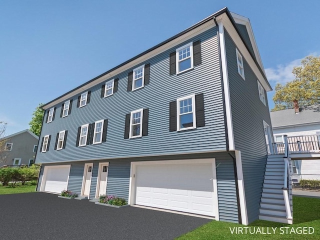 view of front of house with stairs, aphalt driveway, and a garage