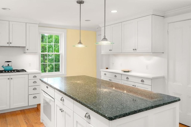 32 School St, Belmont, MA 02478 - kitchen with oven, a center island, light wood-style flooring, gas stovetop, and white cabinetry