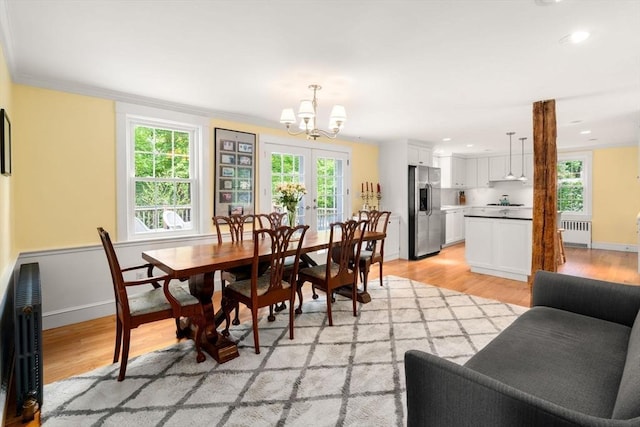 32 School St, Belmont, MA 02478 - dining room with radiator, a chandelier, healthy amount of natural light, light wood-type flooring, and crown molding