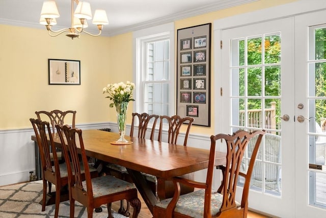 32 School St, Belmont, MA 02478 - dining area featuring a chandelier, ornamental molding, a wainscoted wall, and french doors