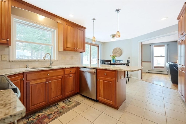 kitchen featuring brown cabinets, a peninsula, hanging light fixtures, stainless steel dishwasher, and a sink