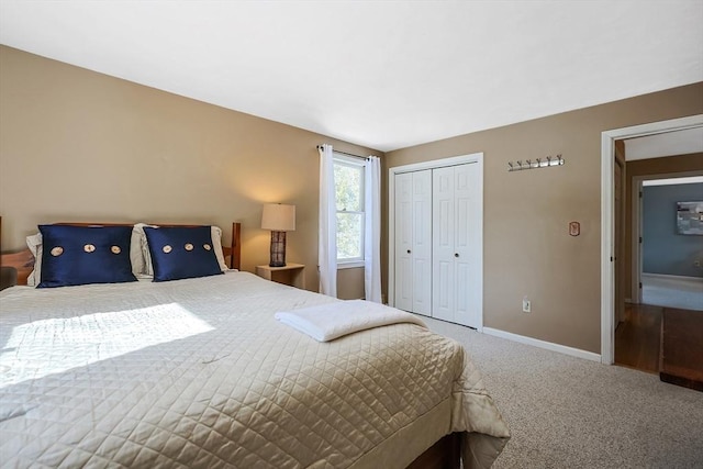 bedroom with carpet floors, baseboards, and a closet