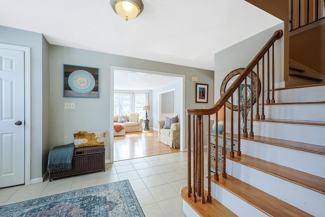 stairway featuring baseboards and tile patterned floors