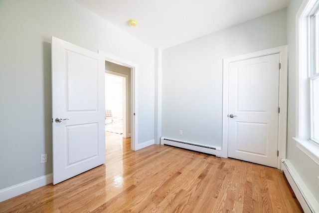 17 Norcross St Unit 3, Arlington, MA 02474 - unfurnished bedroom featuring baseboard heating, a baseboard radiator, light wood finished floors, and multiple windows