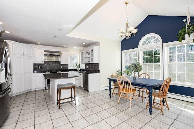 4 Olde Logging Rd, Marion, MA 02738 - kitchen with wall chimney range hood, tasteful backsplash, dark countertops, light tile patterned flooring, and white cabinetry