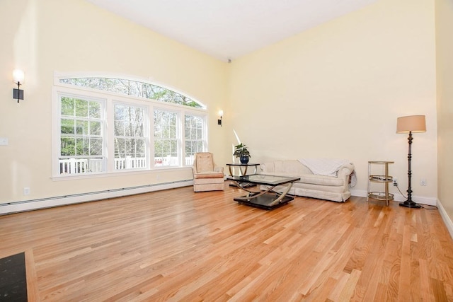 living area with light hardwood / wood-style floors and baseboard heating