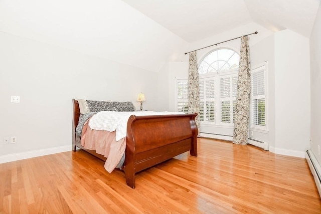 bedroom featuring a baseboard radiator, lofted ceiling, and light wood-type flooring