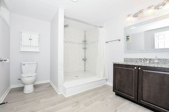 bathroom with a shower with curtain, toilet, vanity, and hardwood / wood-style flooring