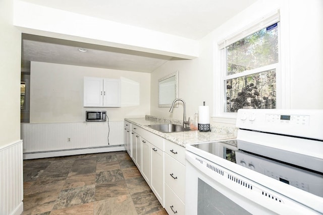 kitchen with white cabinetry, sink, light stone countertops, baseboard heating, and white range