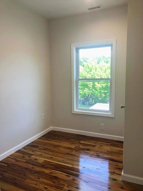 28-32 Calvary St, Waltham, MA 02453 - empty room featuring dark wood-type flooring, visible vents, and baseboards