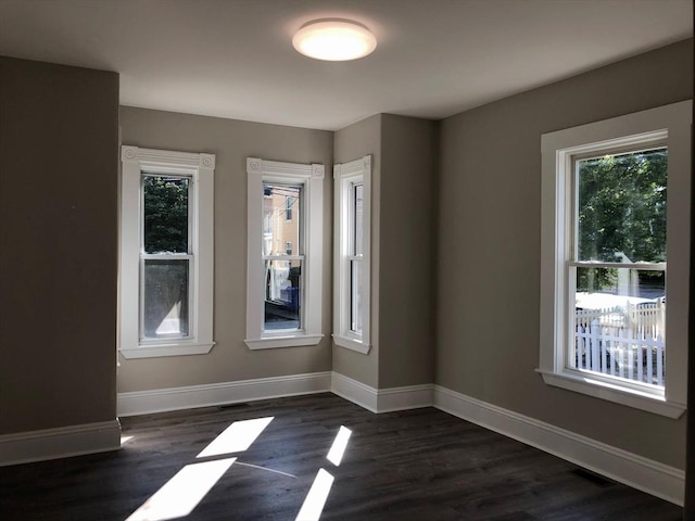 28-32 Calvary St, Waltham, MA 02453 - empty room with dark wood-type flooring, visible vents, and baseboards