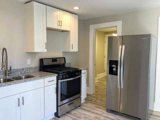 28-32 Calvary St, Waltham, MA 02453 - kitchen featuring stainless steel appliances, light stone counters, a sink, and white cabinets