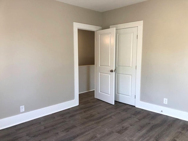 28-32 Calvary St, Waltham, MA 02453 - unfurnished bedroom featuring a closet, dark wood-style flooring, and baseboards