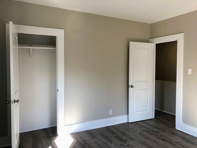28-32 Calvary St, Waltham, MA 02453 - unfurnished bedroom featuring a closet, dark wood finished floors, and baseboards