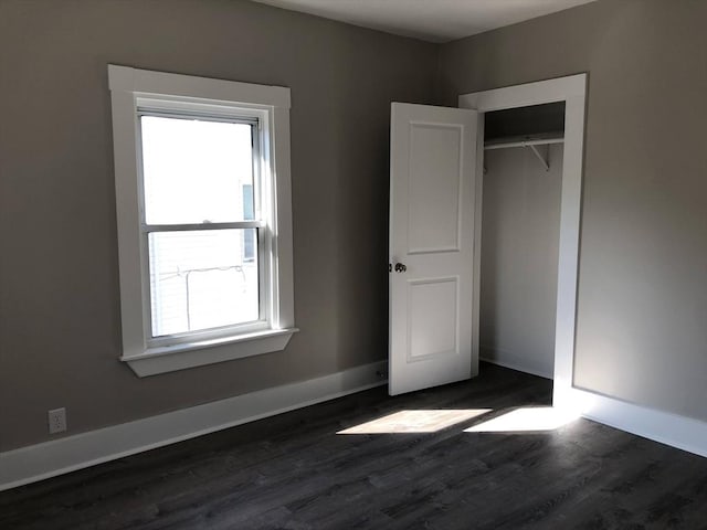 28-32 Calvary St, Waltham, MA 02453 - unfurnished bedroom with a closet, dark wood-style flooring, and baseboards