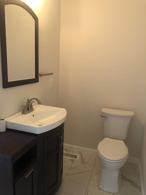 28-32 Calvary St, Waltham, MA 02453 - half bathroom featuring toilet, marble finish floor, baseboards, and vanity
