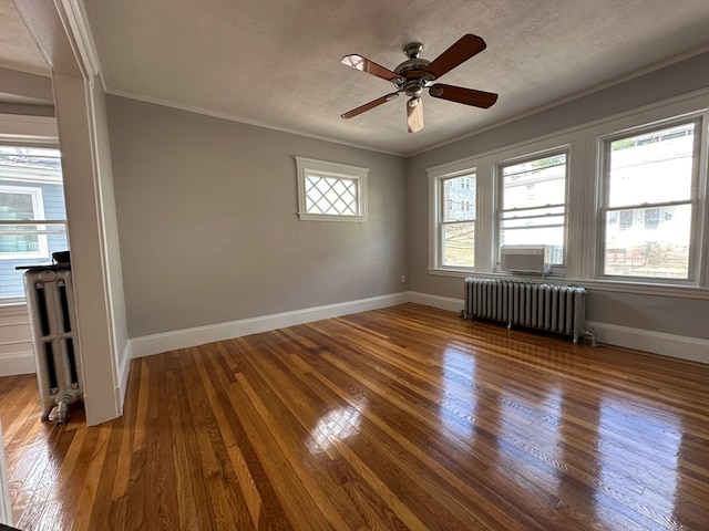 spare room featuring crown molding, radiator heating unit, hardwood / wood-style flooring, and ceiling fan