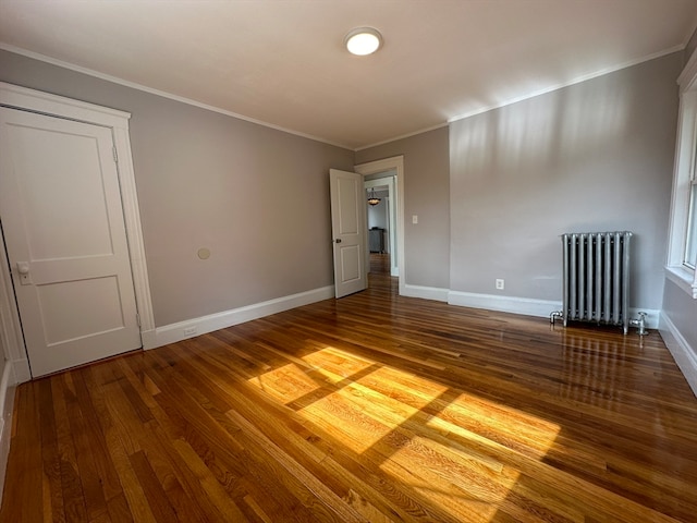 unfurnished room featuring ornamental molding, hardwood / wood-style floors, and radiator