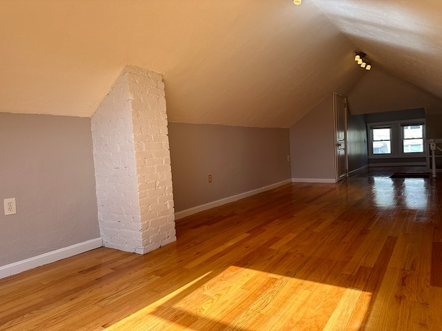 bonus room featuring wood-type flooring and vaulted ceiling