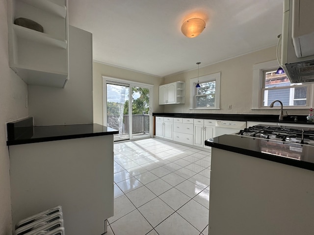 kitchen with white cabinetry, crown molding, light tile patterned floors, and radiator