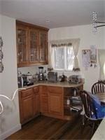 kitchen featuring brown cabinets, light countertops, and dark wood-type flooring