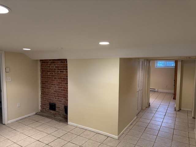 below grade area with a baseboard radiator, light tile patterned floors, baseboards, and recessed lighting