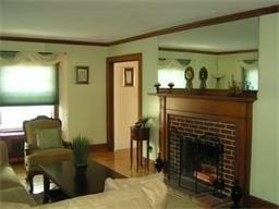 living room featuring wood finished floors and a brick fireplace