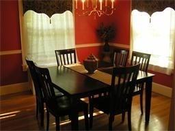 dining area with baseboards, an inviting chandelier, and wood finished floors