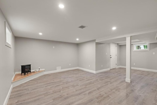 7 Chestnut St, West Newbury, MA 01985 - below grade area with a wood stove, light wood-type flooring, recessed lighting, and baseboards