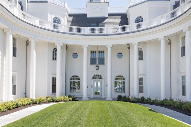 exterior space featuring a balcony and a lawn