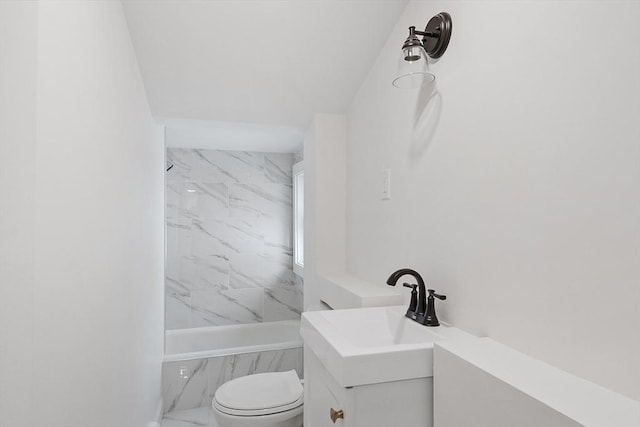 full bathroom featuring tiled shower / bath, vanity, and toilet