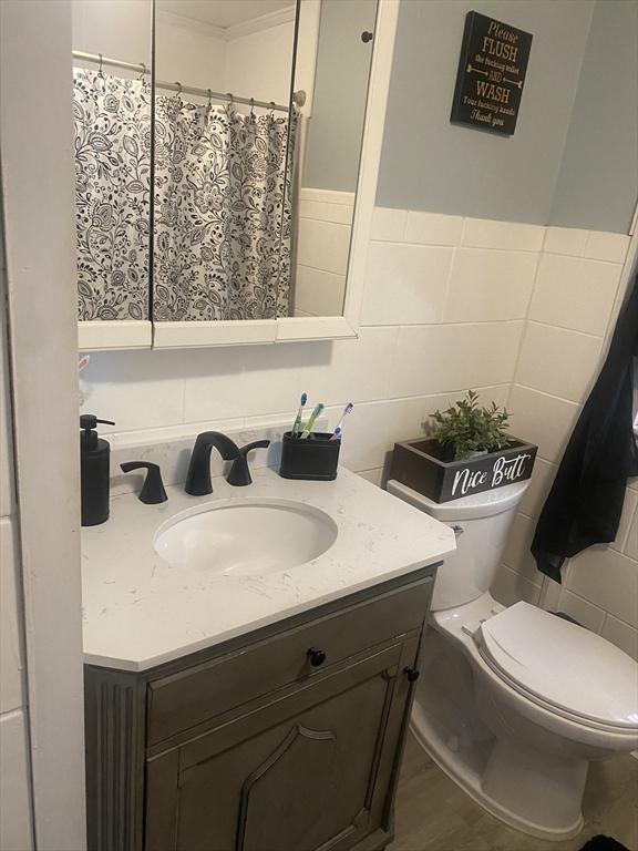 169 Green St, Gardner, MA 01440 - bathroom featuring tile walls, vanity, toilet, and a shower with curtain