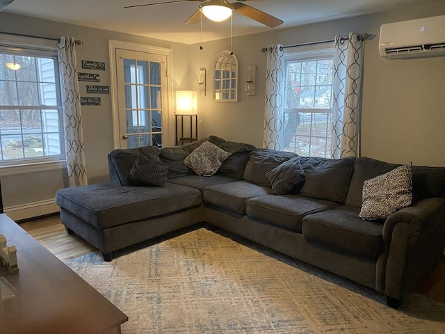 169 Green St, Gardner, MA 01440 - living area with a wall unit AC, baseboard heating, a ceiling fan, and healthy amount of natural light