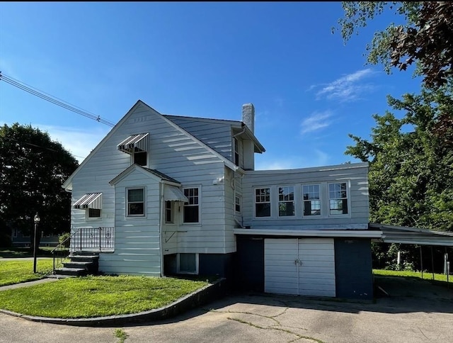 912 Pleasant St, Somerset, MA 02726 - rear view of house with a chimney, asphalt driveway, and an attached garage