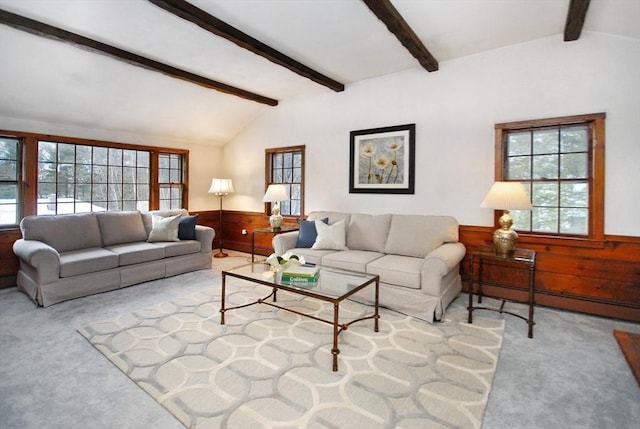 carpeted living area featuring lofted ceiling with beams, baseboard heating, wood walls, and wainscoting