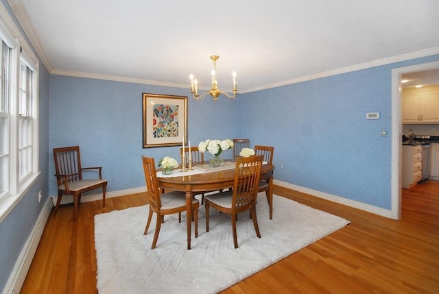 dining room with a baseboard radiator, crown molding, baseboards, and wood finished floors