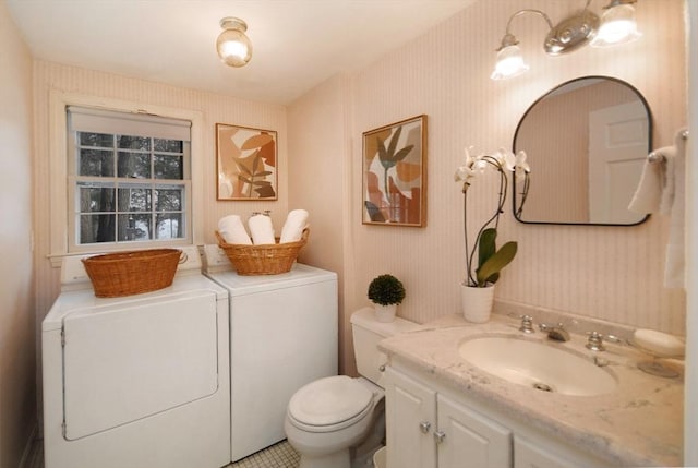 bathroom with independent washer and dryer, vanity, toilet, and wallpapered walls