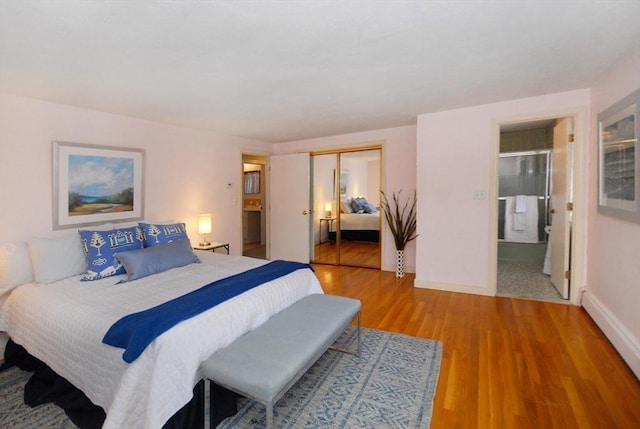 bedroom featuring a closet, baseboards, connected bathroom, and light wood finished floors