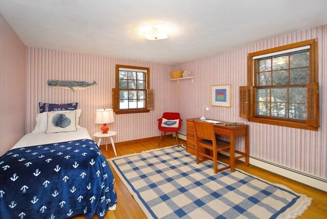 bedroom with wallpapered walls, baseboards, and wood finished floors