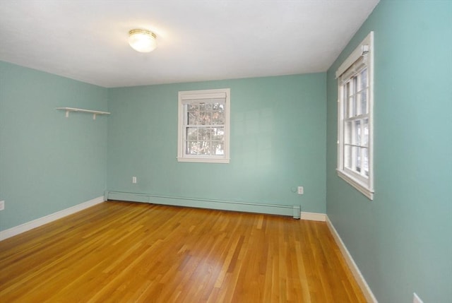 unfurnished room with light wood-type flooring, a baseboard radiator, and baseboards