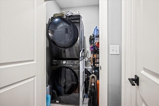 clothes washing area featuring stacked washing machine and dryer