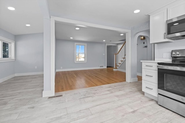 kitchen featuring white cabinetry, stainless steel appliances, and light wood-type flooring